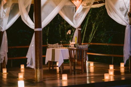 a table in a tent with candles and curtains at Alila Ubud in Ubud