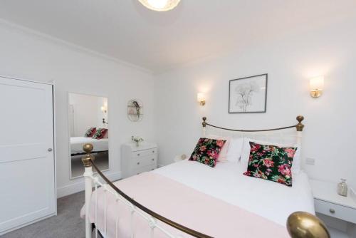 een slaapkamer met een groot wit bed en een spiegel bij Five-bedroom house at Margate, near beach and amenities in Margate