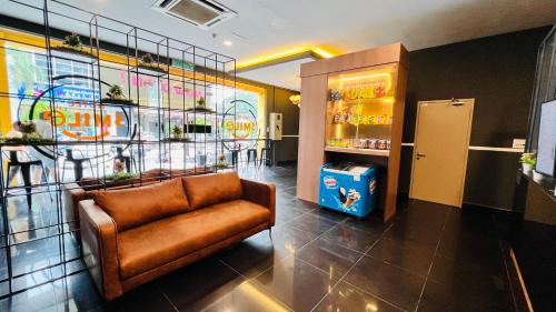 a lobby with a leather chair and a soda shop at Smile Hotel Klang Bukit Tinggi in Kampong Telok Gadong Besar