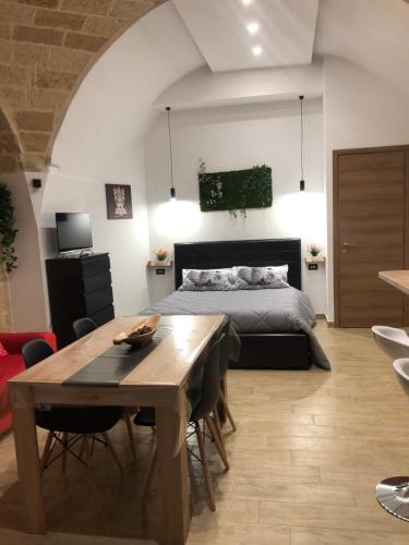 a bedroom with a bed and a table and a dining room at Casa Sipontina in Barletta