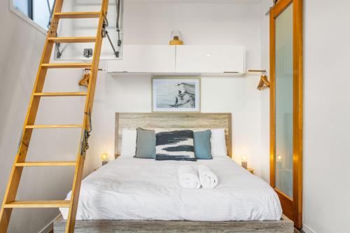 ein Schlafzimmer mit einem Bett mit einer Leiter in der Unterkunft Daybreak Loft in Gold Coast