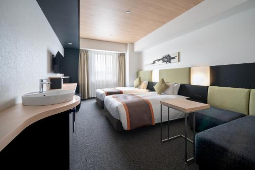 a hotel room with a bed and a sink at Hotel Vista Hiroshima in Hiroshima