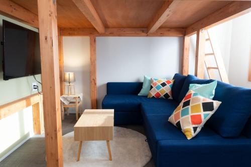 a living room with a blue couch and a tv at 池袋Apila in Tokyo