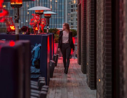 a woman walking down a street with an umbrella at Virgin Hotels Chicago in Chicago