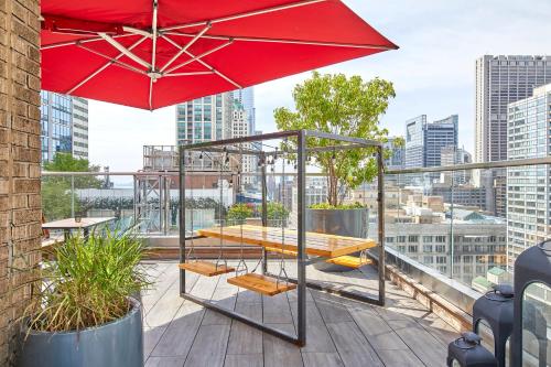 a red umbrella and a table and chairs on a roof at Virgin Hotels Chicago in Chicago