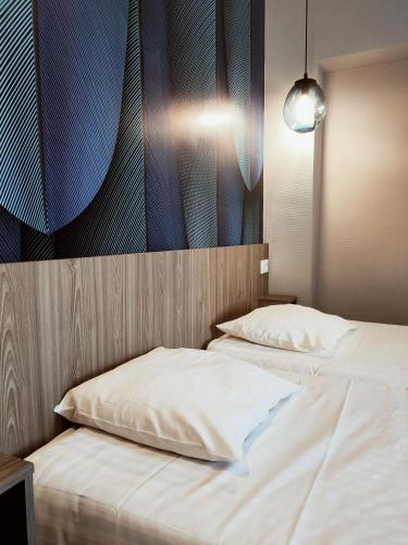 a bedroom with two beds and a painting on the wall at Hotel Iena in Angers
