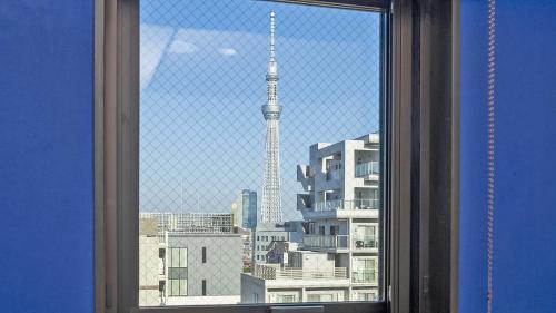 a window with a view of a city with a tower at Stay SAKURA Tokyo ASAKUSA ART DECO HOTEL in Tokyo
