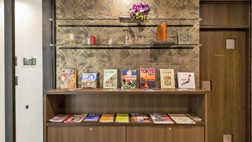 a book shelf with many books on it at Stay SAKURA Tokyo ASAKUSA ART DECO HOTEL in Tokyo