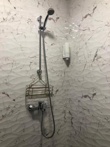 a shower in a bathroom with a wall at Luxury apartment 1 Free Underground Secure Parking in Pazardzhik