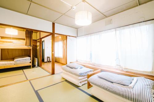a living room with two beds and a window at Guesthouse RICO in Wakayama