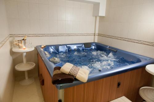 ヒサリャにあるHotel Astreaのバスルーム(青い大型バスタブ、シンク付)