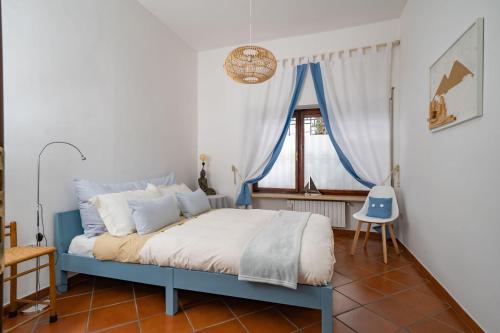 Cama azul en habitación con ventana en Casa Posillipo NA en Nápoles