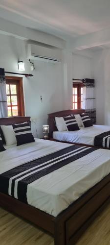 2 Betten in einem Zimmer mit 2 in der Unterkunft Kumudu Home Stay 