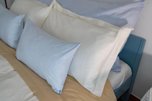 un montón de almohadas encima de una cama en Casa Posillipo NA en Nápoles