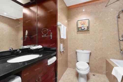 a bathroom with a sink and a toilet and a shower at Kaijia Hotel in Bao'an