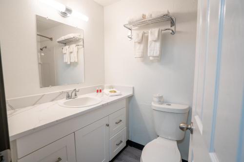 Baño blanco con lavabo y aseo en Kennewick Inn & Suites Tri Cities, en Kennewick