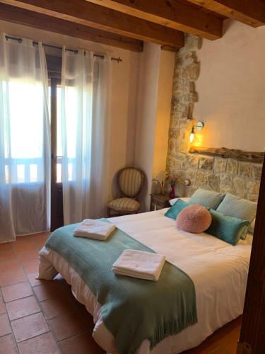 a bedroom with a large bed with towels on it at Casas Rurales Hoces del Duratón in Carrascal del Río