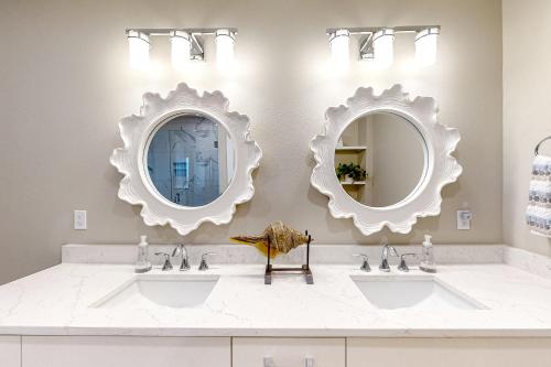 a bathroom with two sinks and mirrors on the wall at Penthouse Sweet in St Pete Beach