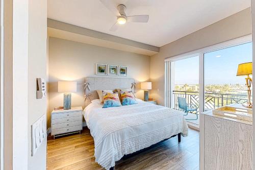 a bedroom with a bed and a balcony at Penthouse Sweet in St. Pete Beach