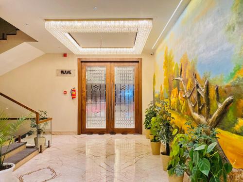 a hallway with plants and paintings on the walls at SJ PARADISE in Dehradun