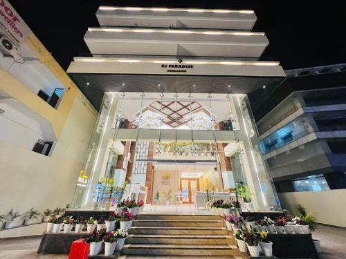 a lobby of a building with stairs and potted plants at SJ PARADISE in Dehradun