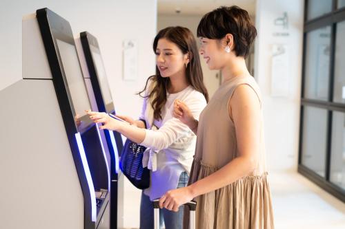 two young women looking at a display in a room at Prince Smart Inn Naha in Naha