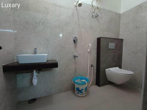 a bathroom with a sink and a toilet at Royal Residency in Kumbakonam