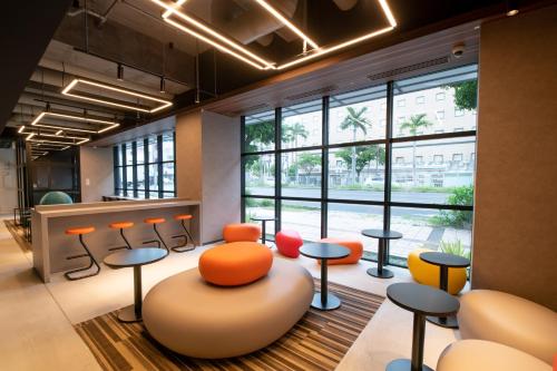 an office with orange chairs and tables and a large window at Prince Smart Inn Naha in Naha