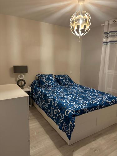 sypialnia z łóżkiem i żyrandolem w obiekcie Belle Maison MALOU climatisée calme, piscine, jacuzzi 3km plage Labenne Capbreton w mieście Labenne