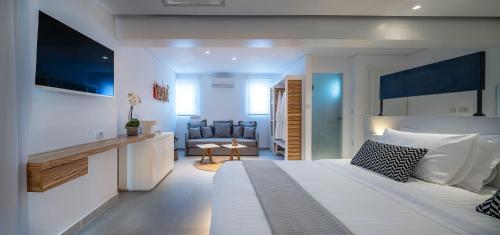 a bedroom with a large bed and a living room at Kantouni Beach Boutique Hotel in Panormos Kalymnos