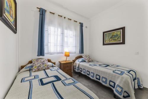 a bedroom with two beds and a window at Villa Nico by EscapeHome in Puerto del Carmen