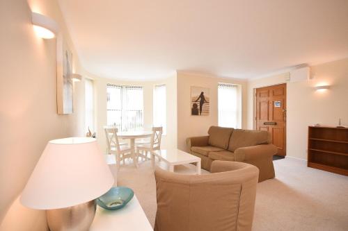 Town or Country - Osborne House Apartments في ساوثهامبتون: غرفة معيشة مع أريكة وطاولة