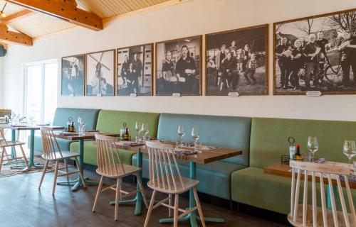 a restaurant with tables and chairs and pictures on the wall at Familie Resort Molenwaard in Ottoland