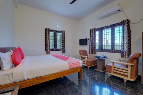 a bedroom with a bed and a desk and a chair at ART Resort & Farm House in Mahabalipuram