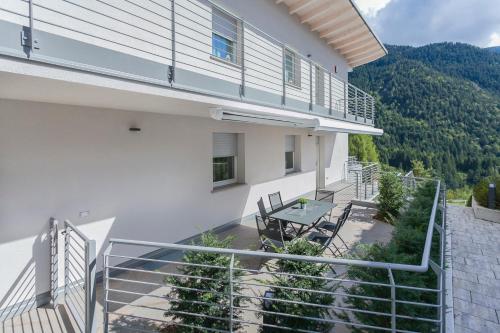 a balcony of a house with a table and chairs at Bellavista - Lake in Molveno