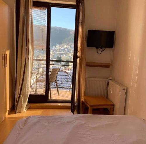 a bedroom with a bed and a window with a view at Villa La Kola Krusevo in Kruševo