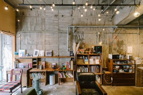 a book store with books on shelves and lights at Guesthouse RICO in Wakayama