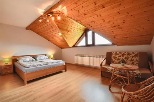 um quarto com uma cama, uma cadeira e uma mesa em Willa Radosna em Rudzica