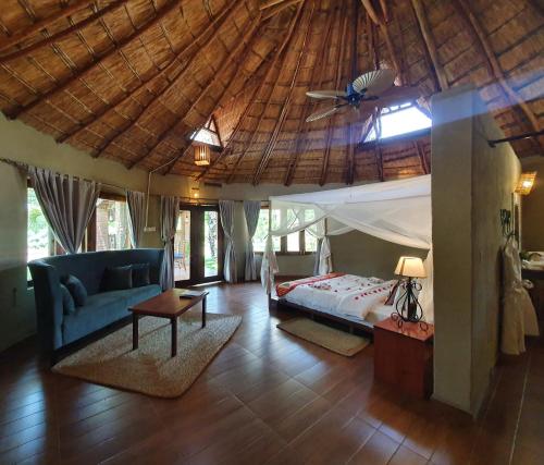 sypialnia z łóżkiem i drewnianym sufitem w obiekcie Zaburi Beach by Serendib w mieście Mangochi