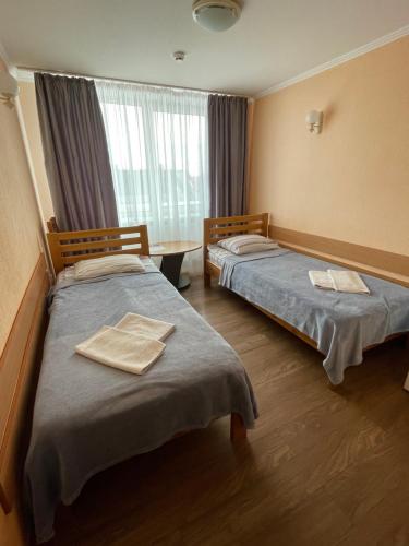 a hotel room with two beds and a window at Готель "Дубно" in Dubno