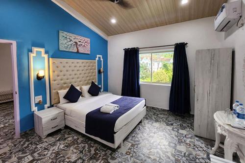 Paradise Village Beach Resort في كالانغيُت: غرفة نوم مع سرير مزدوج كبير ونافذة