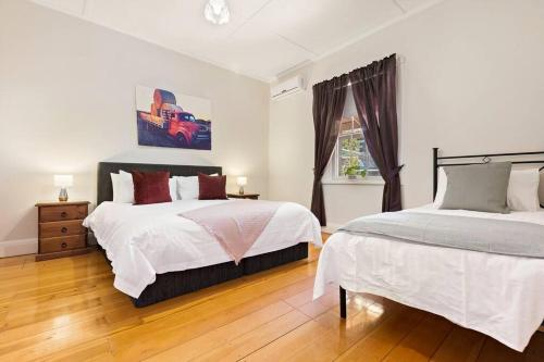 a bedroom with two beds and a window at Tanunda Central Cottage in Tanunda