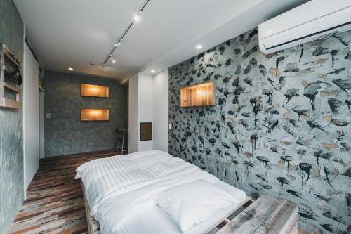 a bedroom with a wall of birds wallpaper at コトリ コワーキング&ホステル高松 in Takamatsu