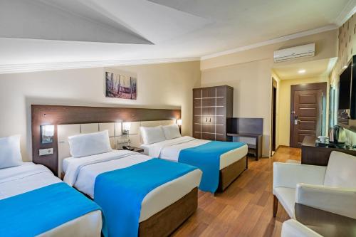 a hotel room with two beds and a television at Buyuk Velic Hotel in Gaziantep