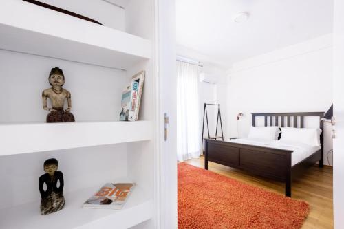 biała sypialnia z łóżkiem i pokój z czerwonym dywanem w obiekcie Comfort Sunny Hub with 2 bdr w Atenach