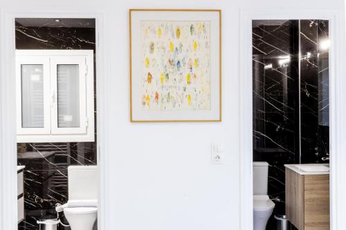 a bathroom with a toilet and a picture on the wall at Comfort Sunny Hub with 2 bdr in Athens