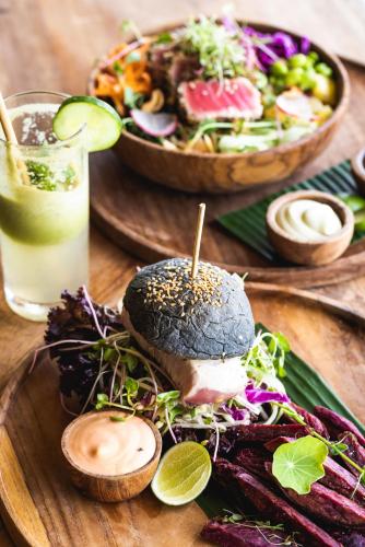 a table with a sandwich and a salad and a drink at Dome Lombok in Bumbang