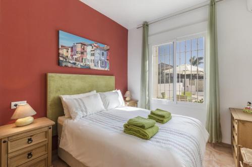 a bedroom with a large bed with red walls and a window at Villa Herrero in Mazarrón