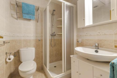 a bathroom with a toilet and a sink and a shower at Villa Herrero in Mazarrón