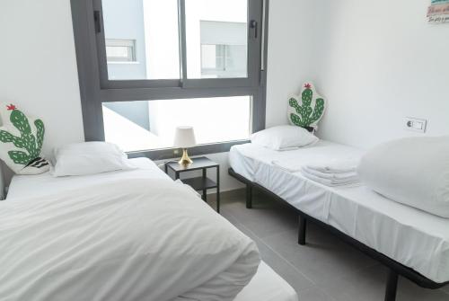 dwa łóżka w pokoju z oknem w obiekcie 3058 Residence Lamar 3058 w mieście Pilar de la Horadada